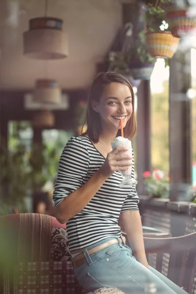 Kobieta siedzi na tarasie kawiarni city i pije milkshake — Zdjęcie stockowe