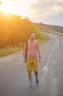 Gülümseyen ve güneşli yaz günü zevk genç adam