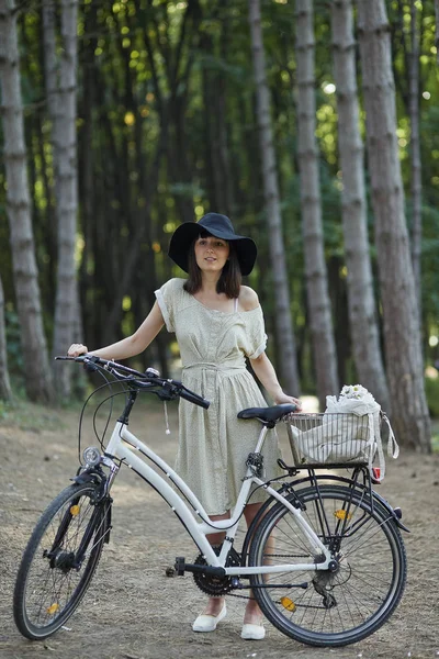 Junge Frau vor Naturkulisse mit Fahrrad — Stockfoto