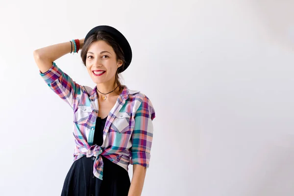 Sorrindo jovem mulher segurando chapéu com braço direito — Fotografia de Stock