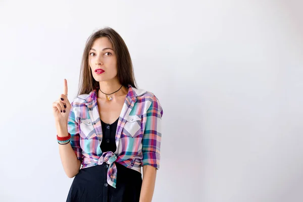 Retrato chica joven apuntando con el dedo hacia arriba —  Fotos de Stock