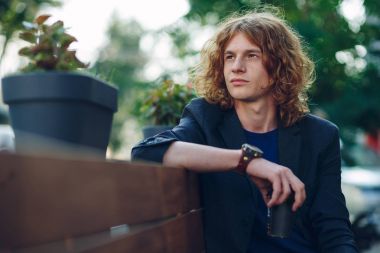 Tezgah düşünme üzerinde oturan kırmızı saçlı hippi adam