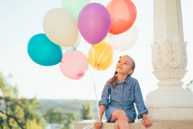 Sevimli kız portre renkli balonlar şehir parkında holding