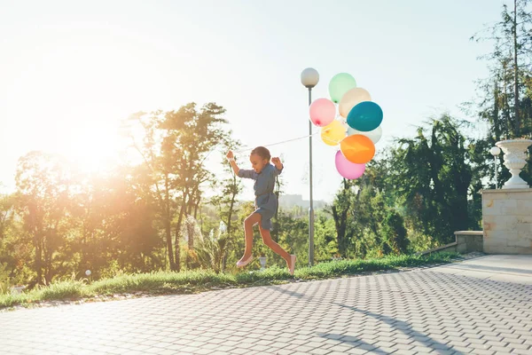 Ładna dziewczyna gospodarstwa kolorowe balony w parku miejskim, gry, r — Zdjęcie stockowe