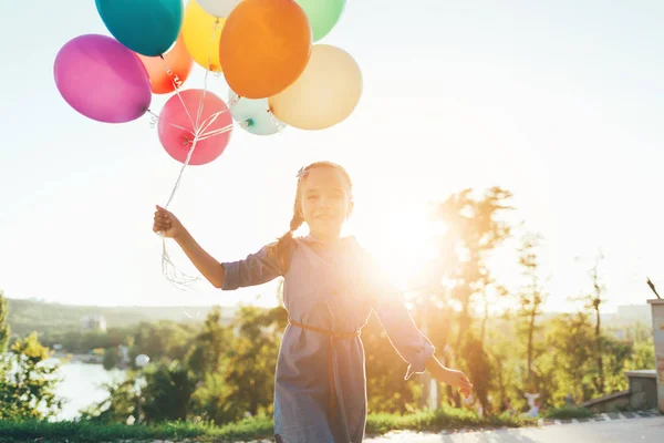 快乐的女孩，在城市公园，玩着五颜六色的气球 — 图库照片