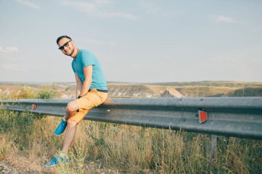 Gülümseyen ve güneşli yaz günü zevk genç adam