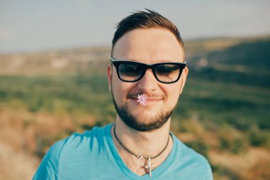 Gülümseyen ve güneşli yaz günü zevk genç adam