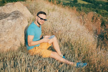 Gülümseyen ve güneşli yaz günü zevk genç adam