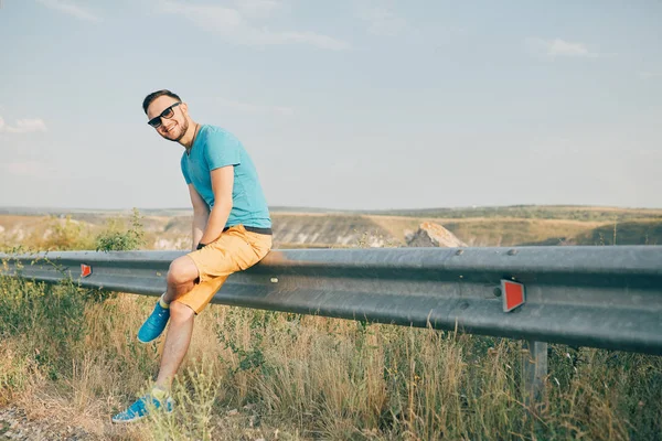 Gülümseyen ve güneşli yaz günü zevk genç adam