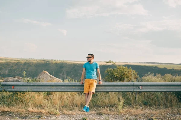 Mladý muž s úsměvem a těší slunečného letního dne — Stock fotografie