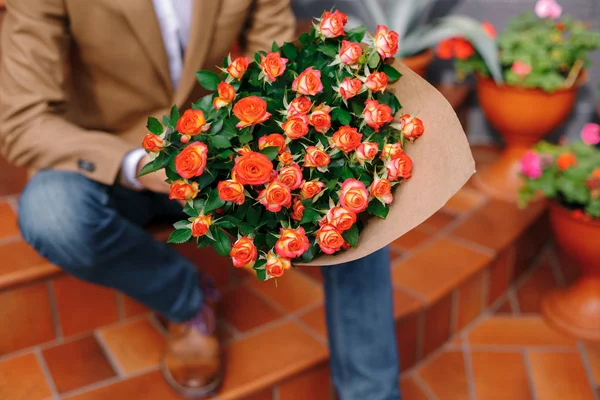 Skupić się na bukiet róż, składany w craft papier przechowywany przez człowieka — Zdjęcie stockowe