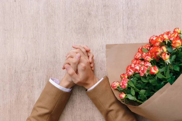 Ακριβή άνθρωπος χέρια με τεμνόμενες φοίνικες και ένα μάτσο τριαντάφυλλα σε cr — Φωτογραφία Αρχείου