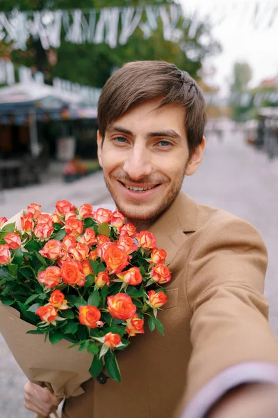 Smiling man making selfie with flowers — Stock Photo, Image