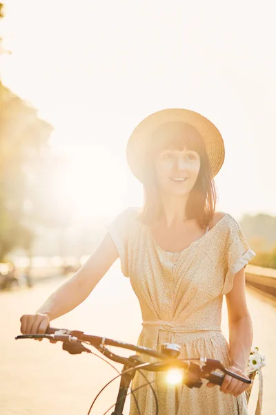 Mujer joven contra el fondo de la naturaleza con bicicleta — Foto de Stock