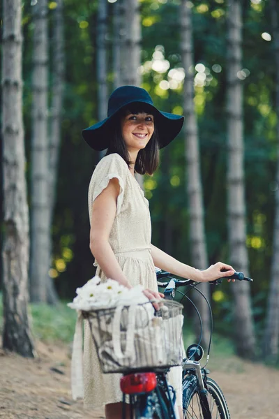 Jovem mulher contra a natureza fundo com bicicleta — Fotografia de Stock