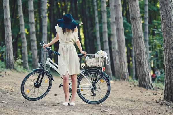 Jovem mulher contra a natureza fundo com bicicleta — Fotografia de Stock