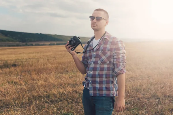 Atraktivní muž fotograf venku při západu slunce — Stock fotografie