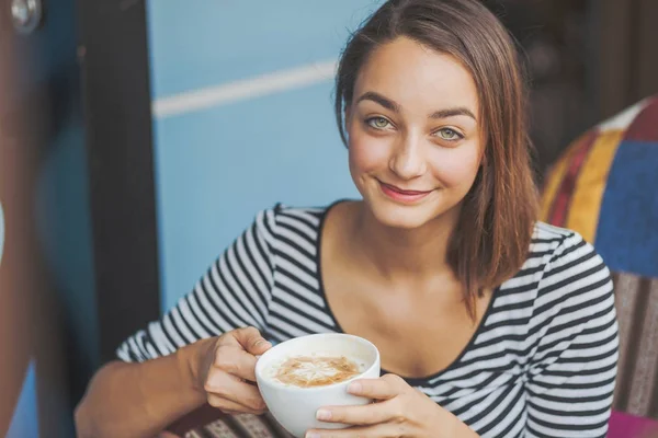 Jonge vrouw zitten binnen in stedelijke café — Stockfoto