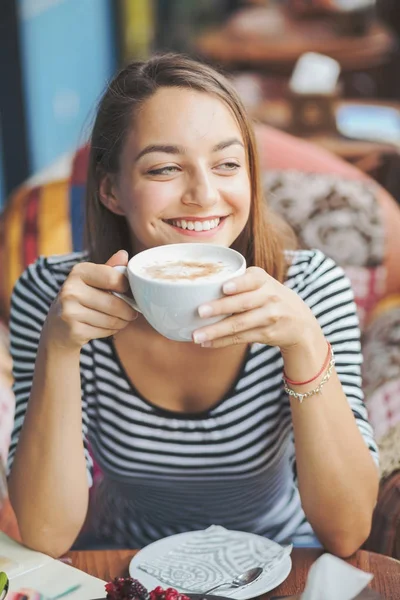 Jonge vrouw zitten binnen in stedelijke café — Stockfoto