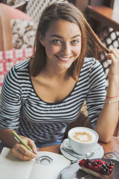 Ung kvinna sitter inomhus i urban café — Stockfoto