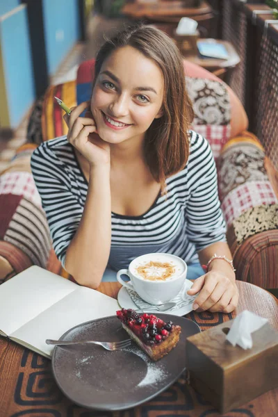 Giovane donna seduta al coperto in un caffè urbano — Foto Stock