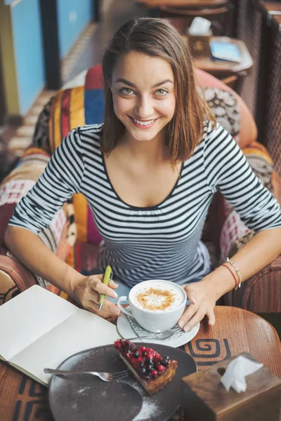 Mujer joven sentada en el interior de un café urbano —  Fotos de Stock