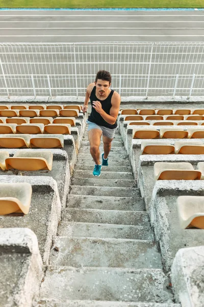 Imagen de un joven atlético corriendo por escalera en el estadio — Foto de Stock