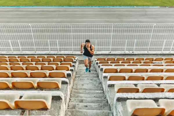 Imagen de un joven atlético corriendo por escalera en el estadio — Foto de Stock