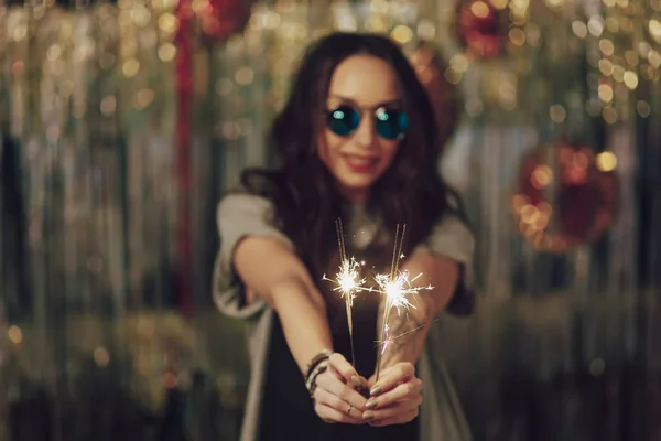 Concentre-se em mãos de mulher segurando sparklers — Fotografia de Stock