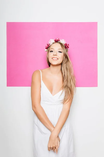 Mulher em vestido de algodão branco com flores no cabelo sorrindo — Fotografia de Stock