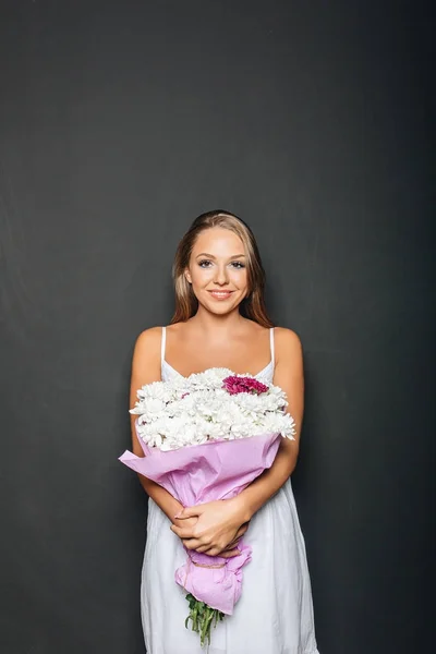 Красивая женщина держит букет цветов — стоковое фото