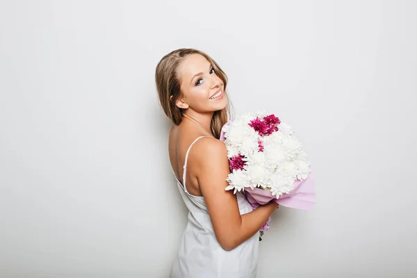 Beautiful woman holding bunch of flowers — Stock Photo, Image