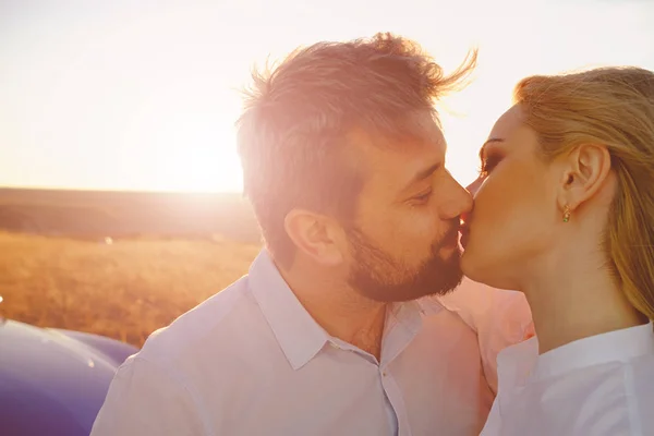Couple kissing on the background of a sunset — Stock Photo, Image