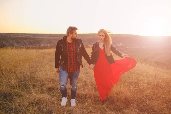 Couple amoureux marchant à travers l'herbe — Photo