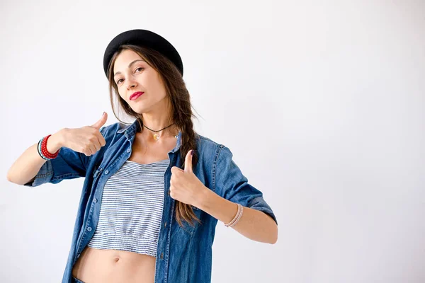 Молодая самоуверенная женщина портрет в шляпе показывая большие пальцы вверх — стоковое фото