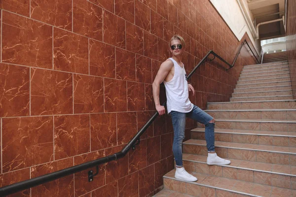 Genç hipster adam ayakta merdivenlerde poz — Stok fotoğraf