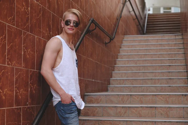 Joven hipster posando de pie en las escaleras — Foto de Stock