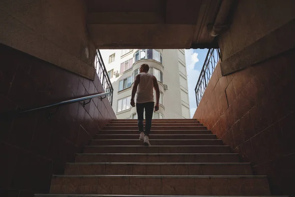Молодой человек поднимается по лестнице в пешеходном метро — стоковое фото