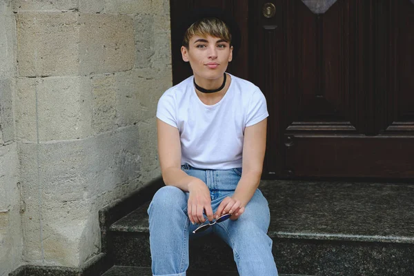 Schöne junge Hipsterfrau posiert sitzend auf der Treppe — Stockfoto