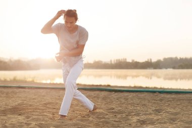 Sahilde hareketleri yapma atletik capoeira sanatçı
