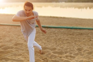 Sahilde hareketleri yapma atletik capoeira sanatçı