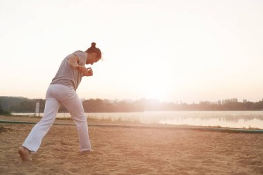 Sahilde hareketleri yapma atletik capoeira sanatçı