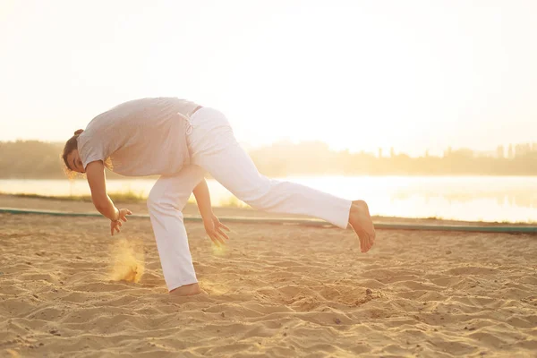 Artista atlético capoeira haciendo movimientos en la playa — Foto de Stock