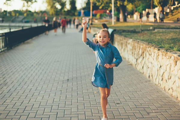Chica jugando, corriendo con juguete avión de papel — Foto de Stock
