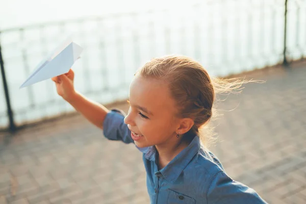Dziewczyna gra, Bieganie z zabawkami papierowy samolot — Zdjęcie stockowe