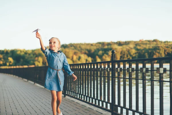 Chica jugando, corriendo con juguete avión de papel — Foto de Stock