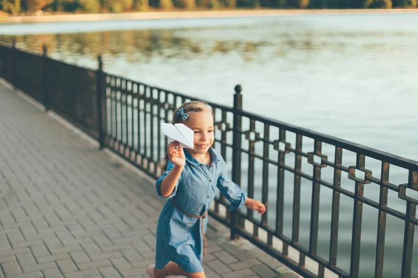 Chica jugando, corriendo con juguete avión de papel — Foto de Stock