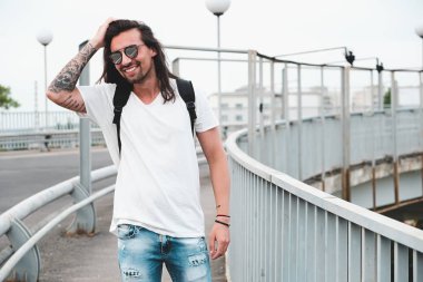 Dışarı, şehirde yürüyüş gülümseyen adam asmak