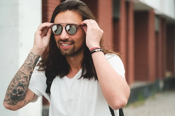 Portrét atraktivní muž se slunečními brýlemi na městské pozadí smil — Stock fotografie