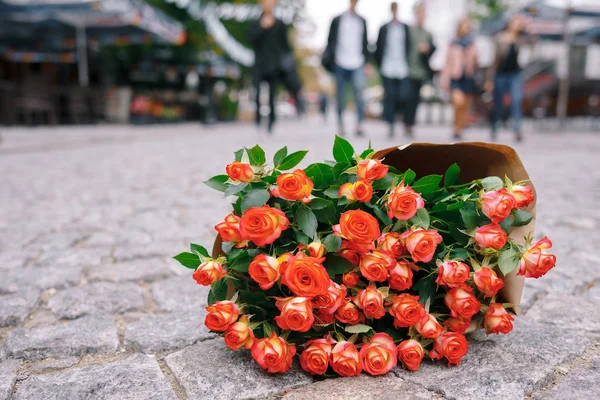 Επικεντρωθεί σε μπουκέτο τριαντάφυλλα σε χαρτί βιοτεχνίας στην οδό pavage γκρι — Φωτογραφία Αρχείου